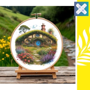 May include: A cross-stitch embroidery hoop featuring a whimsical illustration of a hobbit hole nestled in a lush, green hillside. The artwork includes a blue door, colorful flowers, and a winding path, displayed on a wooden easel.