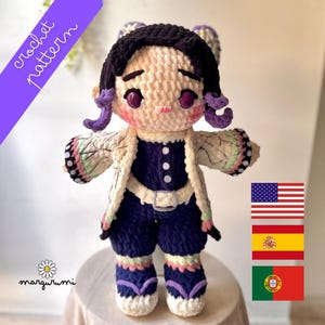 May include: Crocheted doll in the style of an anime character, featuring a cream-colored face, black hair, and purple accents. The doll wears a navy blue outfit with a white jacket and has a floral pattern on the sleeves. The text "crochet pattern" is visible.