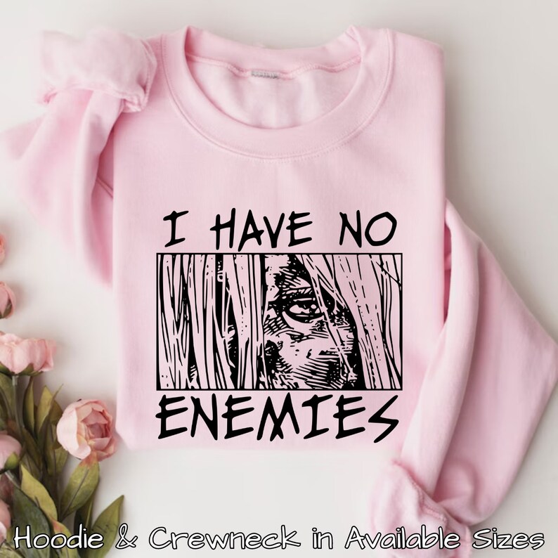 May include: Pink sweatshirt with black text that reads "I have no enemies" and a black and white illustration of an eye.