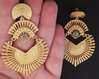 May include: Gold tone dangle earrings with a turquoise stone in the center. The earrings have a geometric design with a fan-shaped bottom.