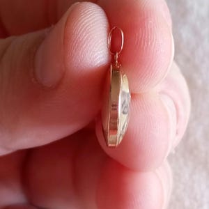 以下が含まれることがあります： 丸い透明なガラス製のインサートが付いたゴールドトーンのペンダント。ペンダントの上部にチェーンに取り付けるためのループがあります。