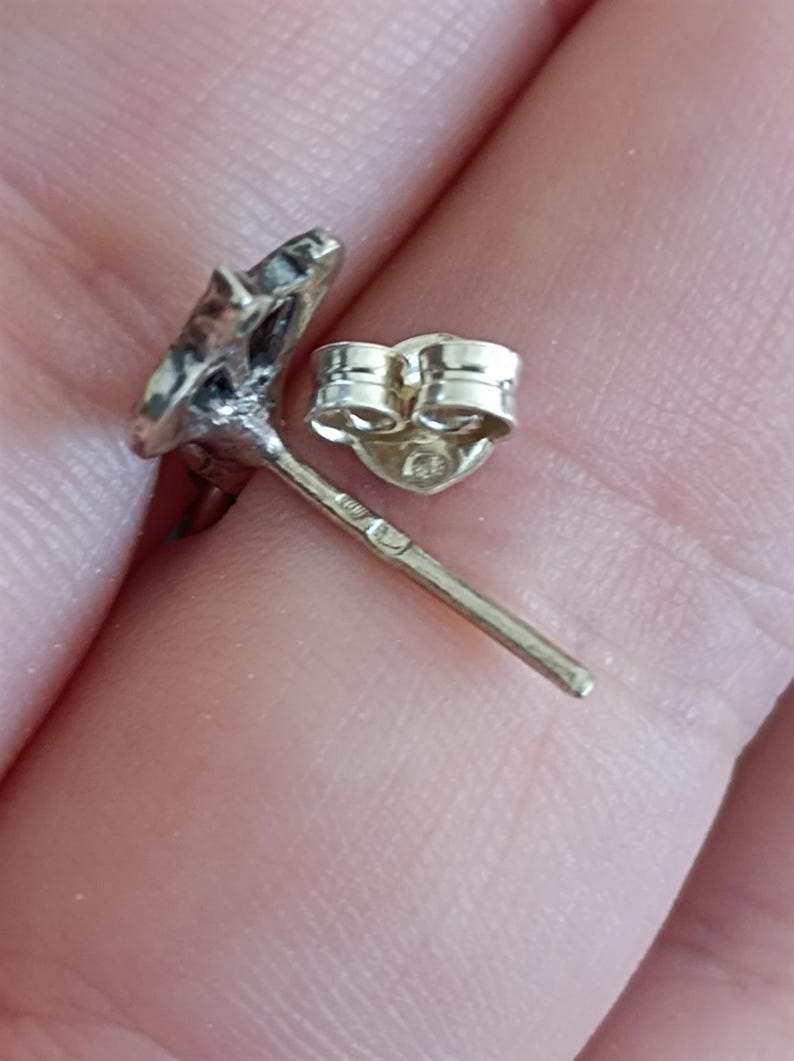 May include: Silver earring with a star-shaped design and a butterfly back.
