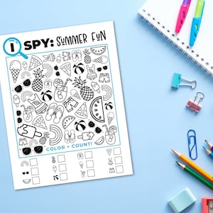 Puede incluir: Una hoja de actividades en blanco y negro "I SPY: SUMMER FUN" con ilustraciones de verano, incluyendo helados y gafas de sol. La hoja est&aacute; sobre una superficie azul claro, rodeada de &uacute;tiles escolares como l&aacute;pices y un cuaderno.