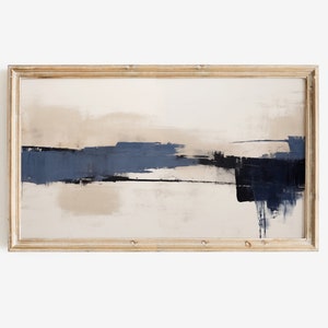 May include: Abstract art print in a rectangular, light-toned wooden frame. The artwork features broad brushstrokes of navy blue, black, and beige against a cream background, creating a minimalist landscape effect. The painting is a horizontal rectangle.