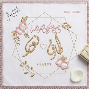May include: White embroidered wedding handkerchief with pink and gold floral and geometric designs. Features Arabic calligraphy and the date 2.25.1/31. The handkerchief has a pink lace border and the text "Jostitch".
