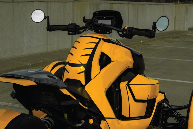 K&ouml;nnte beinhalten: Ein gelb-schwarzes dreir&auml;driges Fahrzeug mit einem schlanken Design. Das Fahrzeug verf&uuml;gt &uuml;ber einen schwarzen Lenker, Seitenspiegel und einen schwarzen Sitz. Der K&ouml;rper hat ein auff&auml;lliges gelb-schwarzes Muster.