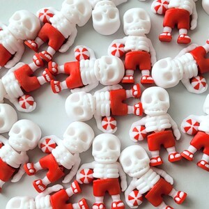 Peut inclure: Une collection de figurines de squelettes blanches portant des shorts rouges et tenant des ballons de plage. Les figurines mesurent environ 2,5 cm de haut.
