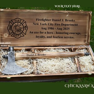 May include: A wooden presentation box with a firefighter's axe. The box is engraved with the Fire Department logo, the name "Daniel J. Brooks", and text honoring courage and service. The axe is displayed on a bed of straw.