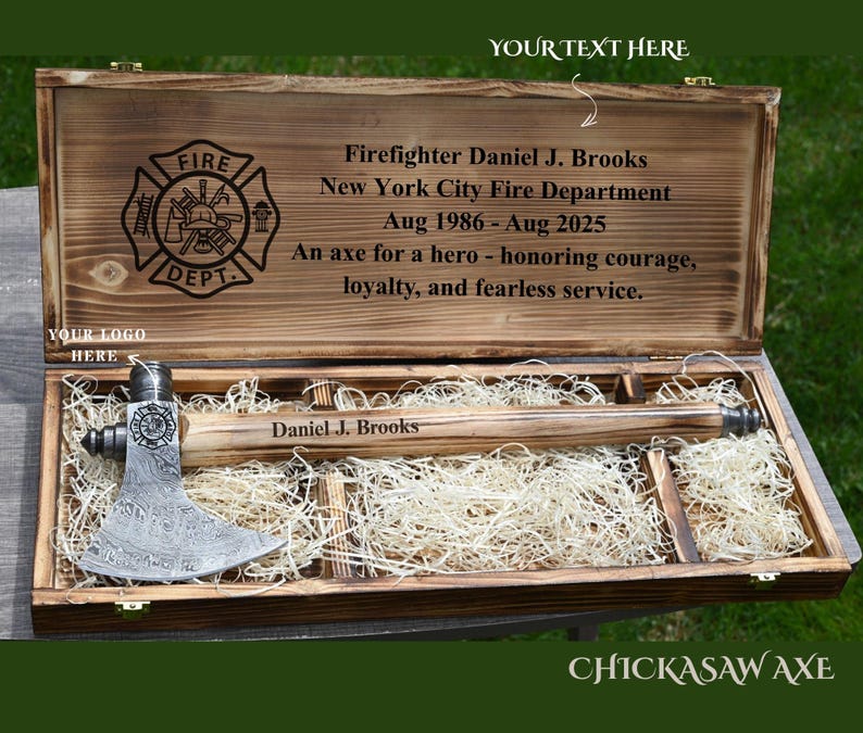 May include: A wooden presentation box with a firefighter's axe. The box is engraved with the Fire Department logo, the name "Daniel J. Brooks", and text honoring courage and service. The axe is displayed on a bed of straw.