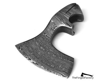 Peut inclure: Une tête de hache en acier Damas présentant un motif métallique ondulé et stratifié distinct sur toute sa surface. La tête de hache comprend un tranchant incurvé et une section de manche découpée. Le logo TheForgedFactory est visible.