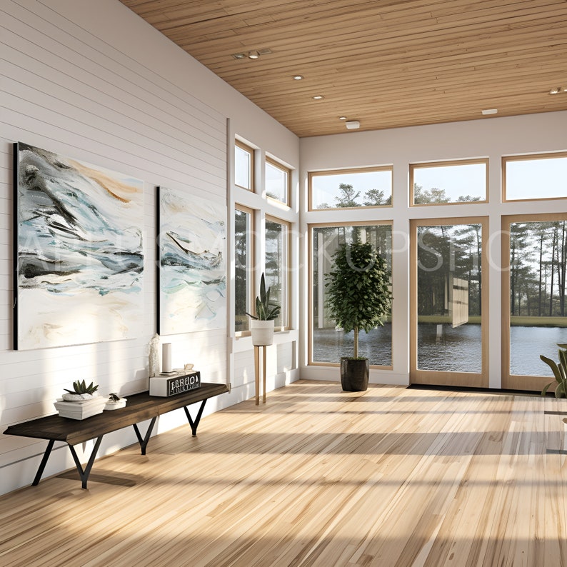 May include: A modern living room with large windows overlooking a lake. The room features a wooden floor, white walls, and a wooden ceiling. Two abstract paintings hang on the wall, and a wooden bench sits in front of them. A potted plant stands in the corner of the room.