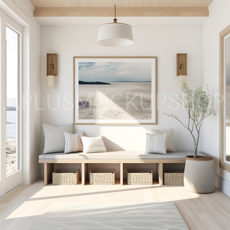 May include: A light wood bench with a cushion and three woven baskets underneath. A framed photograph of a beach scene hangs on the wall above the bench. A small potted plant sits on the floor next to the bench.