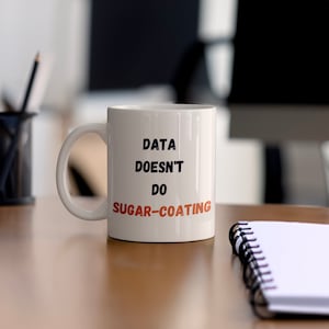Könnte beinhalten: Eine weiße Keramik-Kaffeetasse mit schwarzem Text, der "Data Doesn't Do Sugar-Coating" lautet.