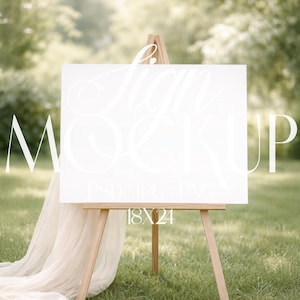 May include: A white sign mockup on a wooden easel, set outdoors on a grassy lawn. The sign displays the text "Sign Mockup" in elegant script. The sign measures 18x24 inches and is draped with a flowing fabric.