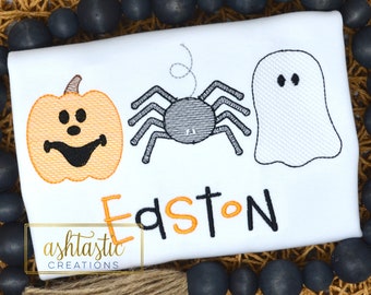 May include: White t-shirt with an embroidered pumpkin, spider, and ghost. The name Easton is embroidered in orange and black letters below the Halloween characters.