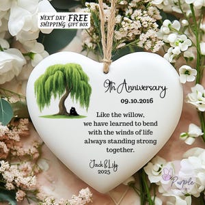 May include: White heart-shaped ceramic ornament featuring a willow tree illustration. Text reads "9th Anniversary 09.10.2016" and a quote about resilience. Includes the names "Jack & Lily" and the year "2025".