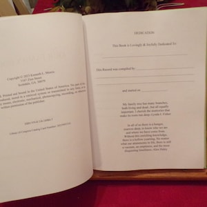 K&ouml;nnte beinhalten: Ein Buch mit einer Widmungsseite. Der Text lautet "Dieses Buch ist mit Liebe und Freude gewidmet an..." und "Diese Aufzeichnung wurde erstellt von... und begonnen am..." Die Widmung setzt sich mit einer Botschaft &uuml;ber Familie und Wurzeln fort.