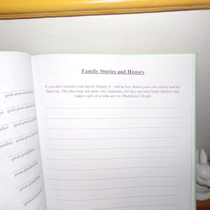 K&ouml;nnte beinhalten: Ein leeres, liniertes Tagebuch mit einem gr&uuml;nen Einband und dem Titel "Family Stories and History" in Schwarz gedruckt. Der Text unter dem Titel lautet: "Wenn du deine Familiengeschichte nicht erz&auml;hlst, geht sie verloren. Ehre deine eigenen Geschichten und erz&auml;hle sie auch. Die Geschichten m&ouml;gen nicht sehr wichtig erscheinen, aber sie sind es, was Familien verbindet und uns zu dem macht, was wir sind. - Madeleine L'Engle"