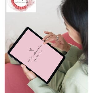 May include: A pink tablet screen with the text "Valientemente" and "Agradecida por los 3 meses" in black. The screen is displaying a logo of a stylized bird with a pink background.