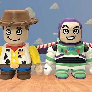 May include: Two character figures from the animated film Toy Story. One figure is dressed as a cowboy with a brown hat, yellow shirt, and blue jeans. The other figure is a space ranger in a green and white suit with purple accents.
