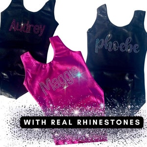 May include: Three leotards with the names Audrey, Phoebe, and Maggie spelled out in rhinestones. The leotards are black and pink. The text "WITH REAL RHINESTONES" is at the bottom of the image.