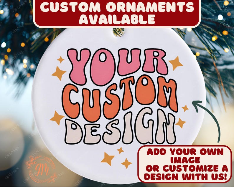 May include: A white, round ornament with the text "YOUR CUSTOM DESIGN" in pink and orange bubble letters. The ornament has a hole at the top for hanging and is decorated with star shapes. Text at the top reads "CUSTOM ORNAMENTS AVAILABLE".