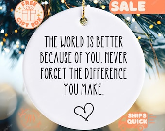 May include: White round ornament with black text that reads "The world is better because of you. Never forget the difference you make." A small heart is in the center of the ornament.