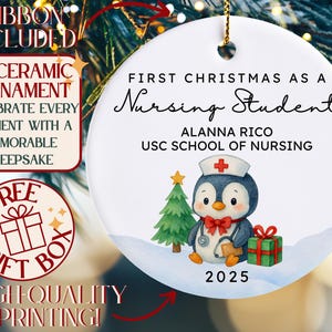 May include: A white ceramic Christmas ornament with gold hanging string. The ornament features a penguin in a nurse's hat, a Christmas tree, and a gift. Text reads "First Christmas as a Nursing Student" and "2025". The ornament is 3 inches in diameter.