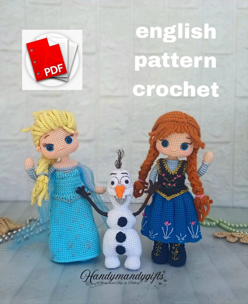 May include: Crocheted dolls of Elsa, Anna, and Olaf from the movie Frozen. Elsa wears a blue dress with a cape, Anna has a black bodice and blue skirt, and Olaf is a white snowman. The words "english pattern crochet" are visible.