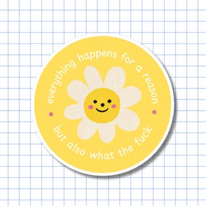 May include: A circular yellow sticker featuring a central white daisy with a yellow centre, a smiling face, and pink cheeks. The text "everything happens for a reason but also what the fuck" is printed in white around the flower.