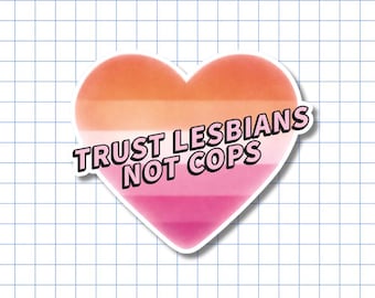 May include: A heart-shaped sticker featuring a horizontal gradient of orange, pink, and white stripes. The text "TRUST LESBIANS NOT COPS" is printed across the center in bold, black, sans-serif capital letters with a thin white outline.