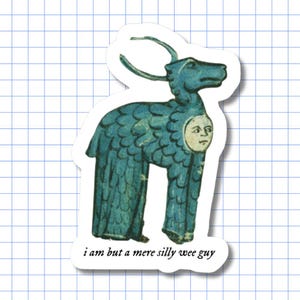 May include: A die-cut sticker featuring a blue, feathered, horned creature with a human face on its side. Below the creature, the text reads, "i am but a mere silly wee guy." The design is presented against a white background with a grid pattern.