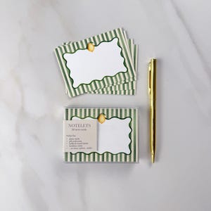 May include: A set of 30 mini cards with a green and white striped border and a lemon illustration. The cards are in a clear plastic box, with a gold pen resting beside them. The cards are designed for place cards, gift enclosures, and more.