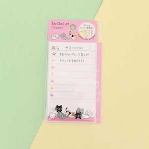 May include: Pink to-do list notepad with a cat illustration and the text "やることリスト" which translates to "To-do list" in English. The notepad has a checkmark and paw prints next to the text "旅行のプランを考える!" which translates to "Think about travel plans!" in English. The notepad also has the text "チケットを予約する!" which translates to "Book tickets!" in English.