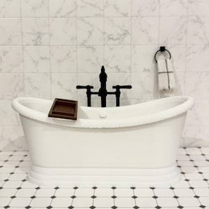 Peut inclure: Une baignoire blanche sur pieds avec un robinet noir mat et un petit plateau en bois brun posé sur le rebord. La baignoire est placée devant un mur en carrelage de marbre blanc et un sol au motif géométrique composé de carreaux noirs et blancs.