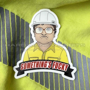 May include: A sticker featuring a cartoon illustration of a man wearing a white hard hat and glasses, with a yellow shirt. The sticker has the text "SOMETHING'S FUCKY" in a banner.