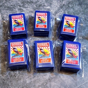 May include: Six blue boxes of Sunshine Ultramarine Blue dye, each with a red bird and sunburst design. The boxes are individually packaged in clear plastic bags.
