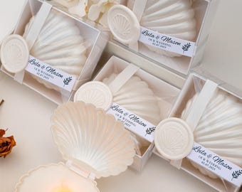 Recuerdos de boda personalizados con velas en forma de concha marina: Regalo para invitados en una caja de ostras, ideal para bodas en la playa o despedidas de soltera.