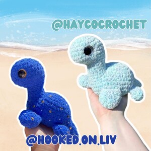 May include: Two crocheted turtle plushies. One is a deep blue with gold star accents, the other is a light blue. The text "@HAYCOCROCHET" and "@HOOKED.ON.LIV" are visible.