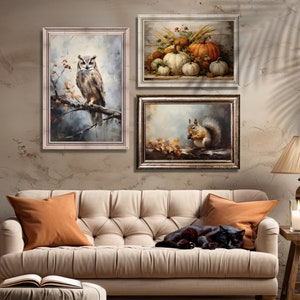 May include: Three framed wall art prints with autumnal themes. The first print features a brown and white owl perched on a branch with fall leaves. The second print shows a group of pumpkins and gourds. The third print depicts a squirrel holding a nut with fall leaves on the ground.