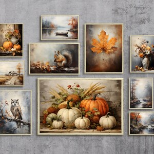 May include: A collection of framed fall-themed artwork featuring pumpkins, squirrels, owls, leaves, and landscapes. The artwork is displayed on a gray wall.