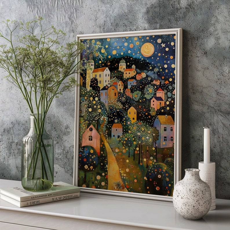 May include: A framed painting of a whimsical village scene with colorful houses, trees, and a winding path. The sky is a dark blue with white stars and a bright yellow moon.