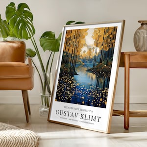 May include: Framed art print featuring a landscape painting with a river and trees in shades of blue, gold, and brown. The print is labeled "20th Century Exhibition" and "Gustav Klimt" with text below. The frame is a light wood color.