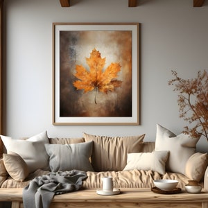 May include: A framed print of a single, dried, orange maple leaf on a textured, brown background.