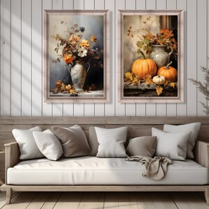 May include: Two framed paintings with a fall theme. The first painting features a white vase with orange and yellow flowers. The second painting features a white pitcher with three pumpkins.