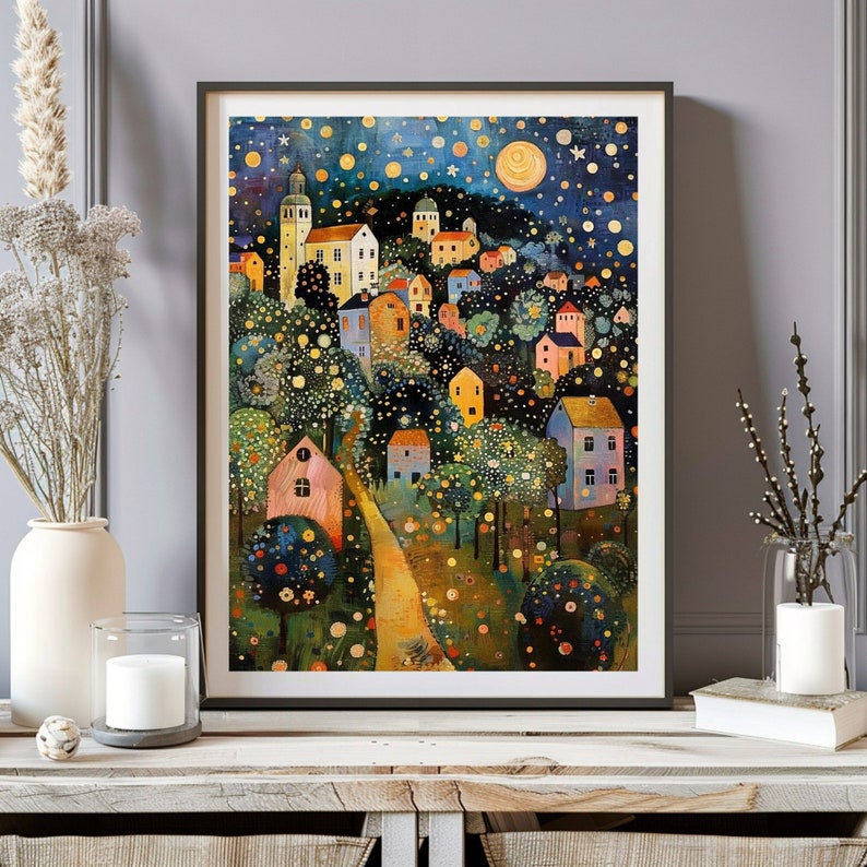 May include: A framed art print depicting a whimsical village scene under a starry night sky. The artwork features colorful houses, trees, and a winding path, with a large moon and a church tower. The color palette includes blues, yellows, and greens.