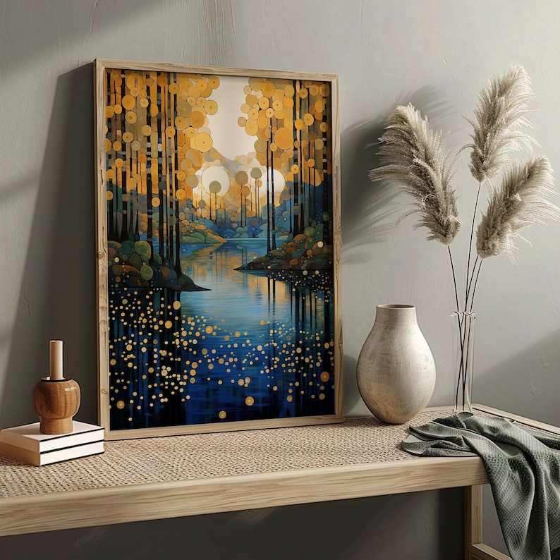 May include: A framed print of a stylized landscape with a blue lake and golden trees. The trees are made up of circles and the lake reflects the trees. The print is on a wooden table with a vase and dried flowers.