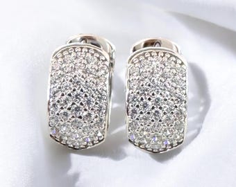 Puede incluir: Un par de pendientes de aro de plata con engaste pavé de pequeños diamantes transparentes.