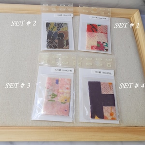 May include: Four sets of small, square fabric patches in clear plastic bags, labeled SET #1 through SET #4. Each bag contains 18mm fabric pieces with various floral and geometric patterns in colors including red, pink, purple, green, and gold.