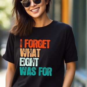 May include: A black t-shirt with a retro-style graphic that reads "I forget what eight was for". The graphic is in orange, red, yellow, blue, and green.
